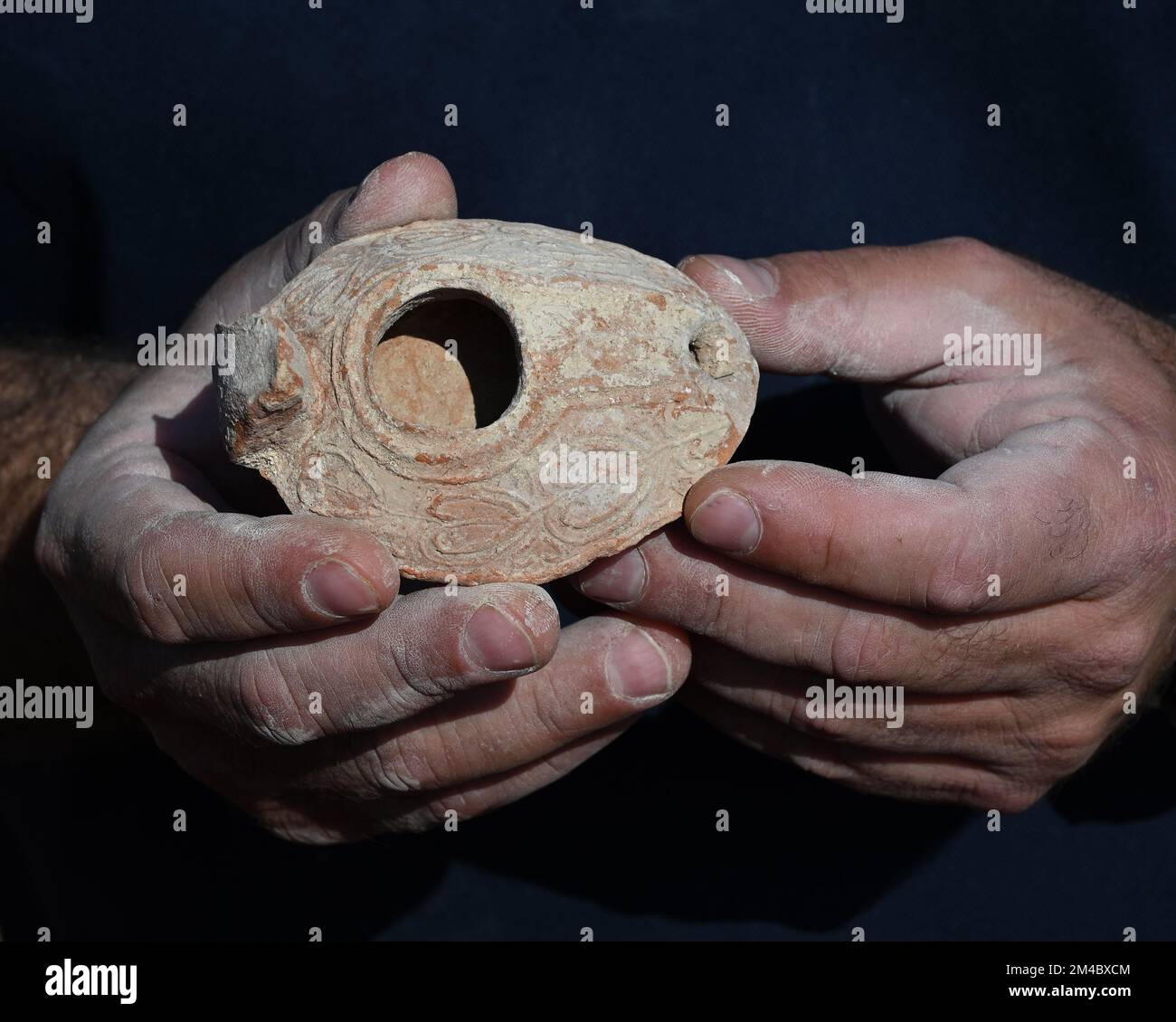 An archeologist from The Israel Antiquities Authority holds a clay lamp from the eighth and ninth centuries CE, unearthed in the courtyard of an elaborate 2,000 year old Second Temple Period family burial cave, known as the Salome Cave, in the Lachish Forest in the Judean lowlands, on Tuesday, December 20, 2022. Archeologists say the cave was continued to be used in the Byzantine and Early Islamic Periods and became known as the Salome Cave due to the tradition that believes it is the burial place of Salome, the midwife of Jesus. Photo by Debbie Hill/ UPI Stock Photo