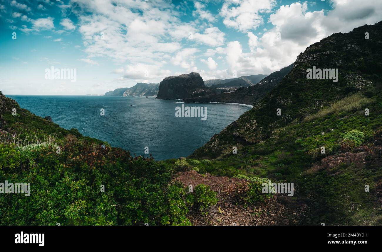 a body of water surrounded by a lush green hillside Stock Photo Alamy