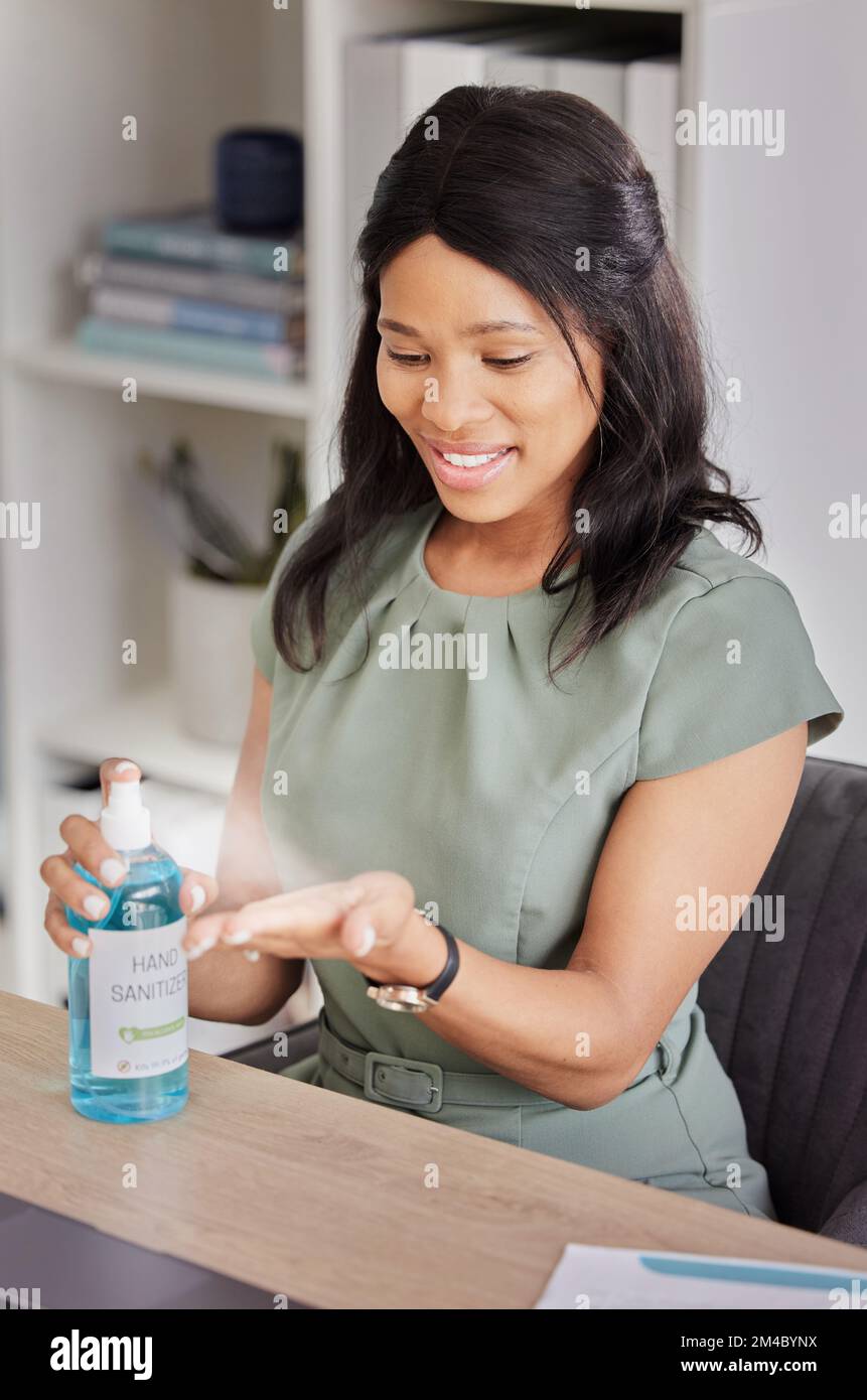 Hand sanitizer, hygiene and black woman at desk in office cleaning