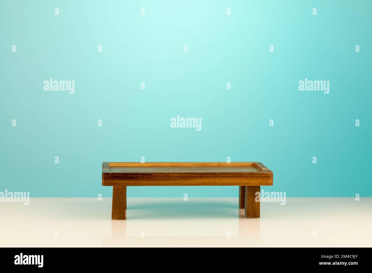 Wooden empty podium for food, products or cosmetics against blue gradient background. Small decorative table for product, display presentation or mont Stock Photo
