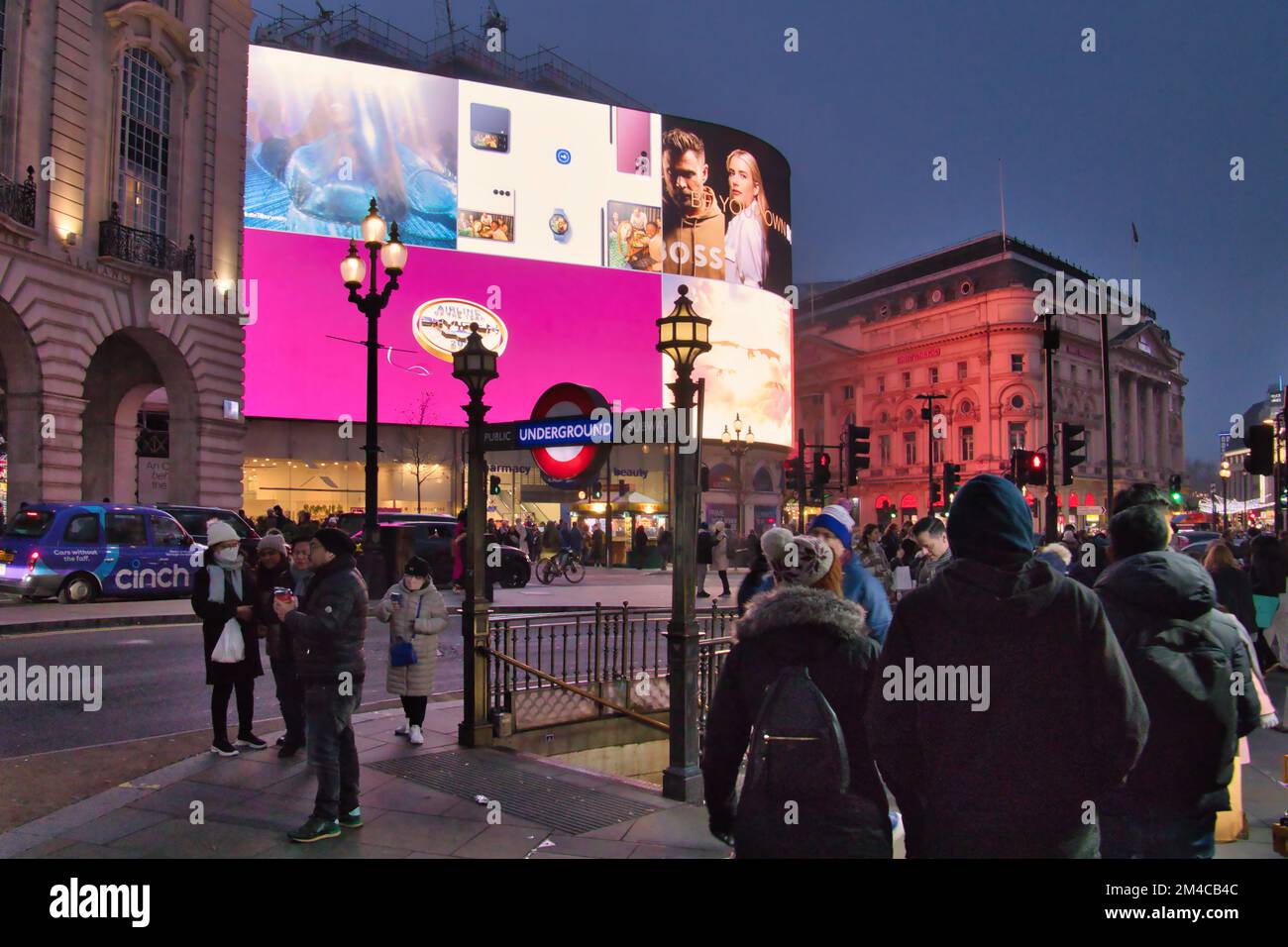 Crowds of people near the lit billboards and tube station at Piccadilly Circus, London, England, UK Stock Photo