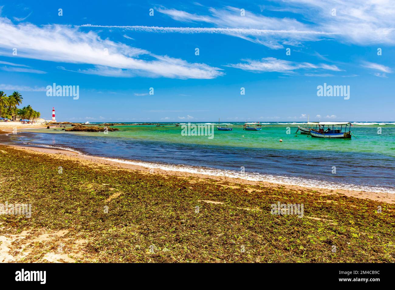 Itapua beach and lighthouse, one of the most beautiful and well-known landscapes in the city of Salvador in Bahia with its anchored fishing boats Stock Photo