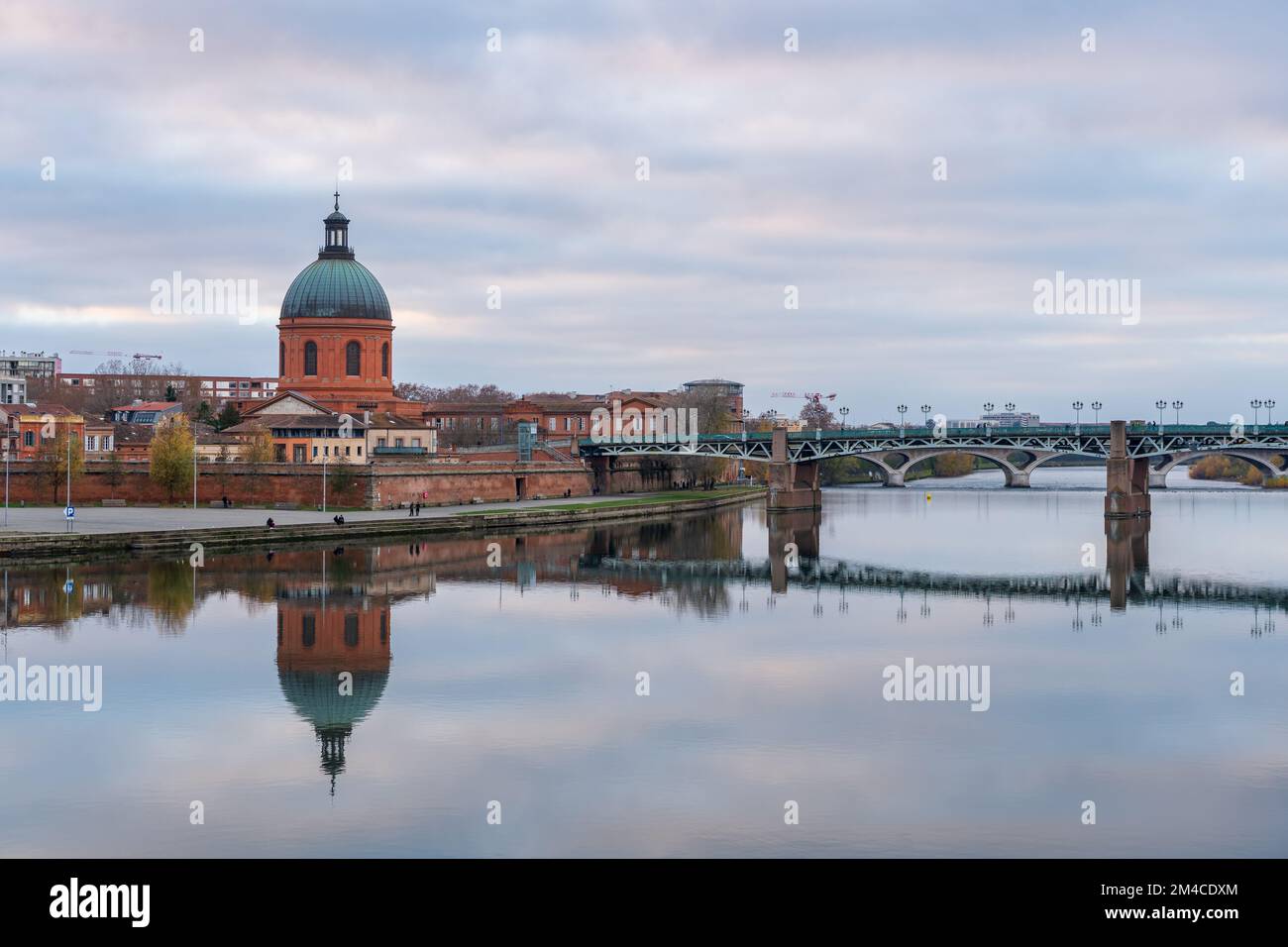 Scenic cityscape view on the dome of St Joseph de la Grave chapel and St Peter bridge with reflection in Garonne river, Toulouse, France Stock Photo