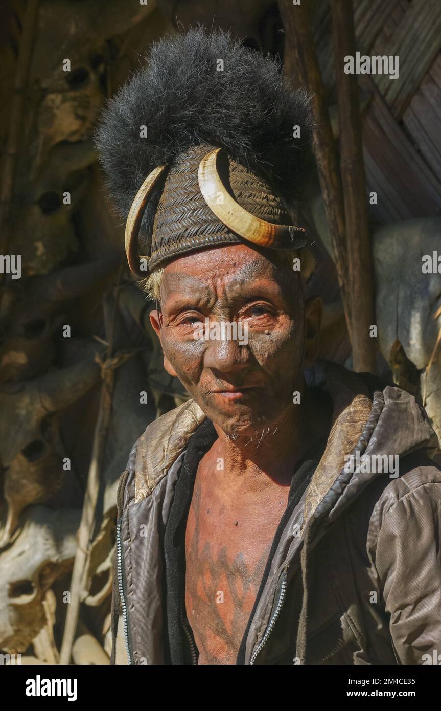 Mon, Nagaland, India - 11 25 2013 : Portrait of old Naga Konyak tribe head hunter warrior with facial and chest tattoo wearing traditional cane hat Stock Photo