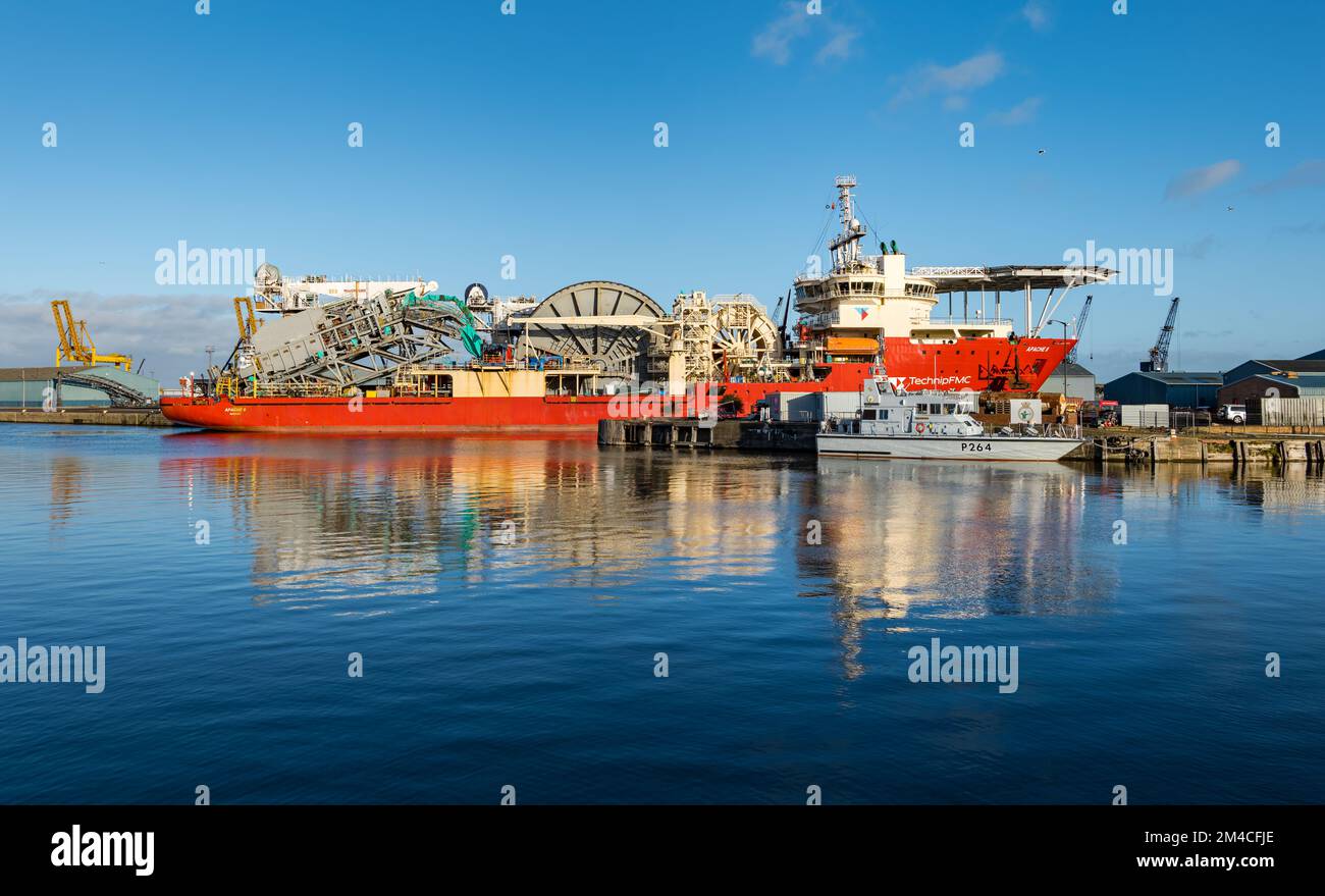 Technip Apache II offshore supply ship and HMS Archer MoD training vessel reflected calm water in Leith Harbour, on sunny day Edinburgh, Scotland, UK Stock Photo