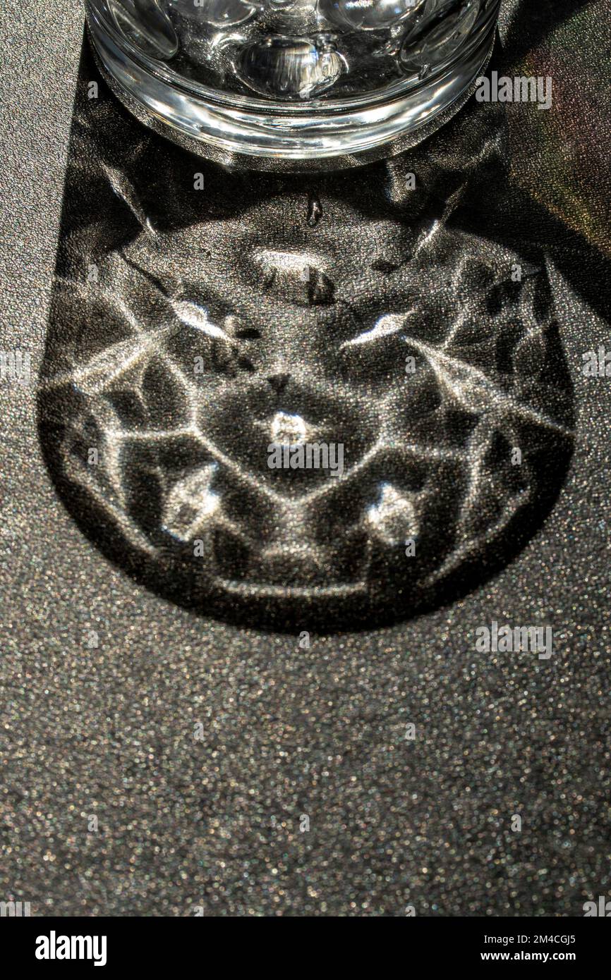 Natural close up still-life patterns formed by crystal glass on a work surface Stock Photo