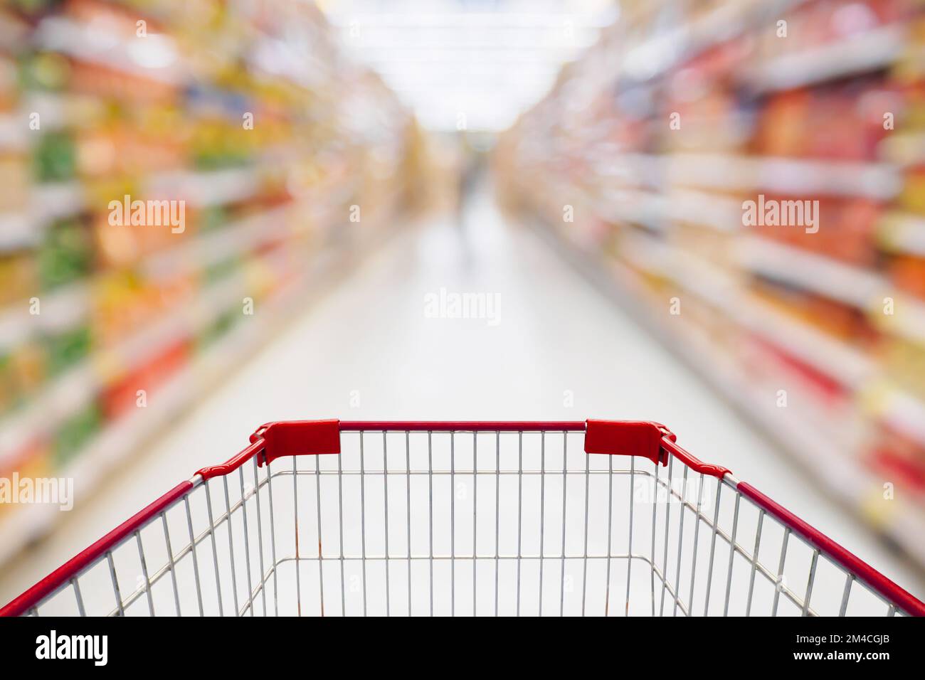 Shopping cart view in Supermarket aisle with product shelves abstract blur defocused background