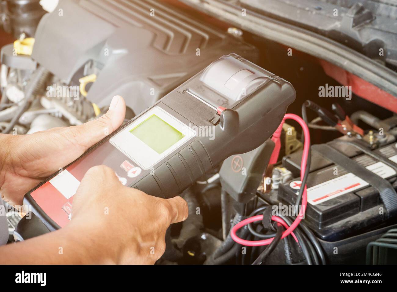 mechanic use voltmeter checking voltage of car battery in car service