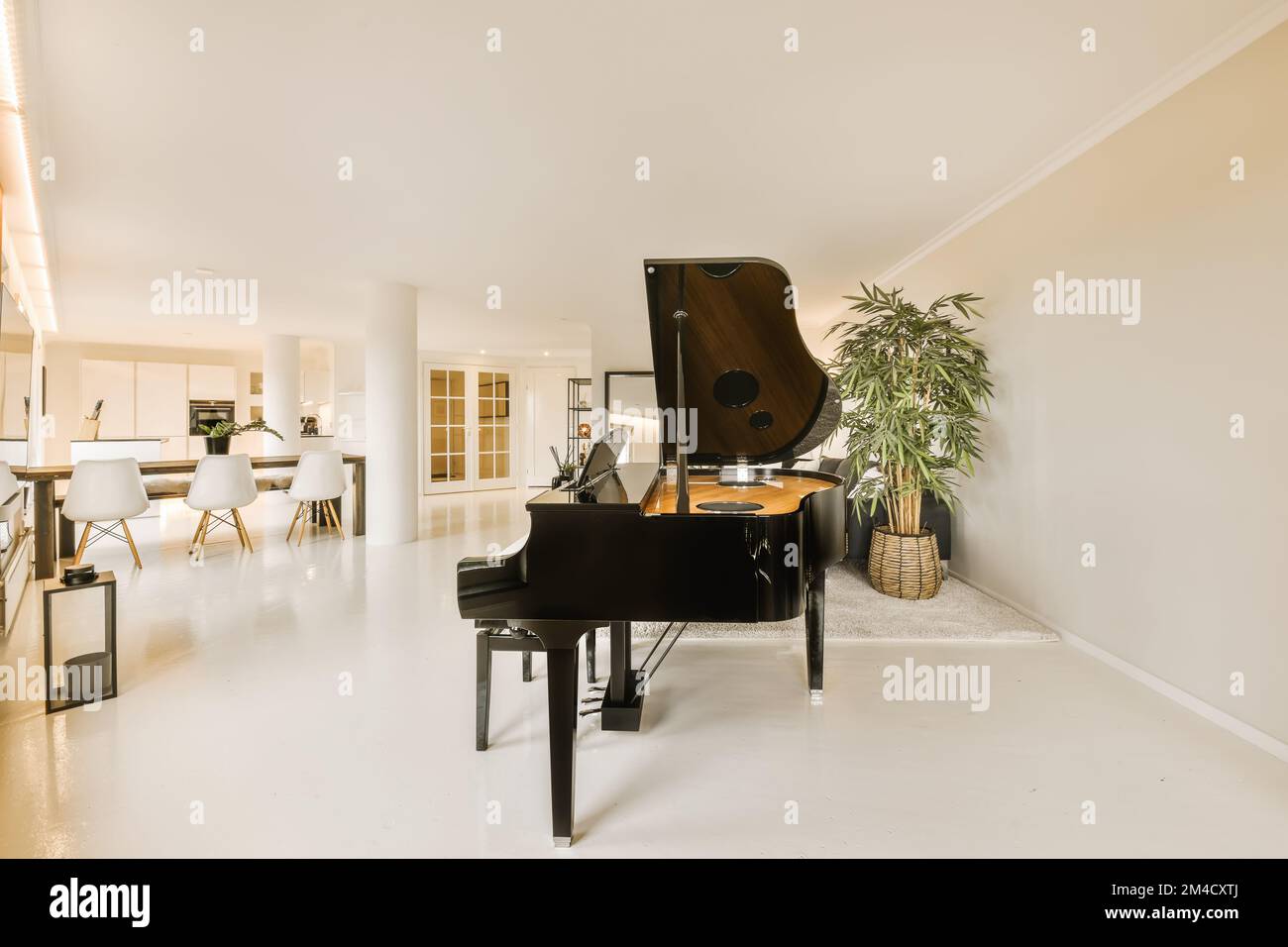 a living room with a piano in the middle and an open dining area on the
