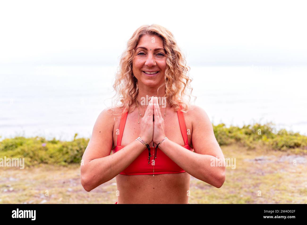 Portrait of smiling sporty woman doing yoga in parkland Stock Photo