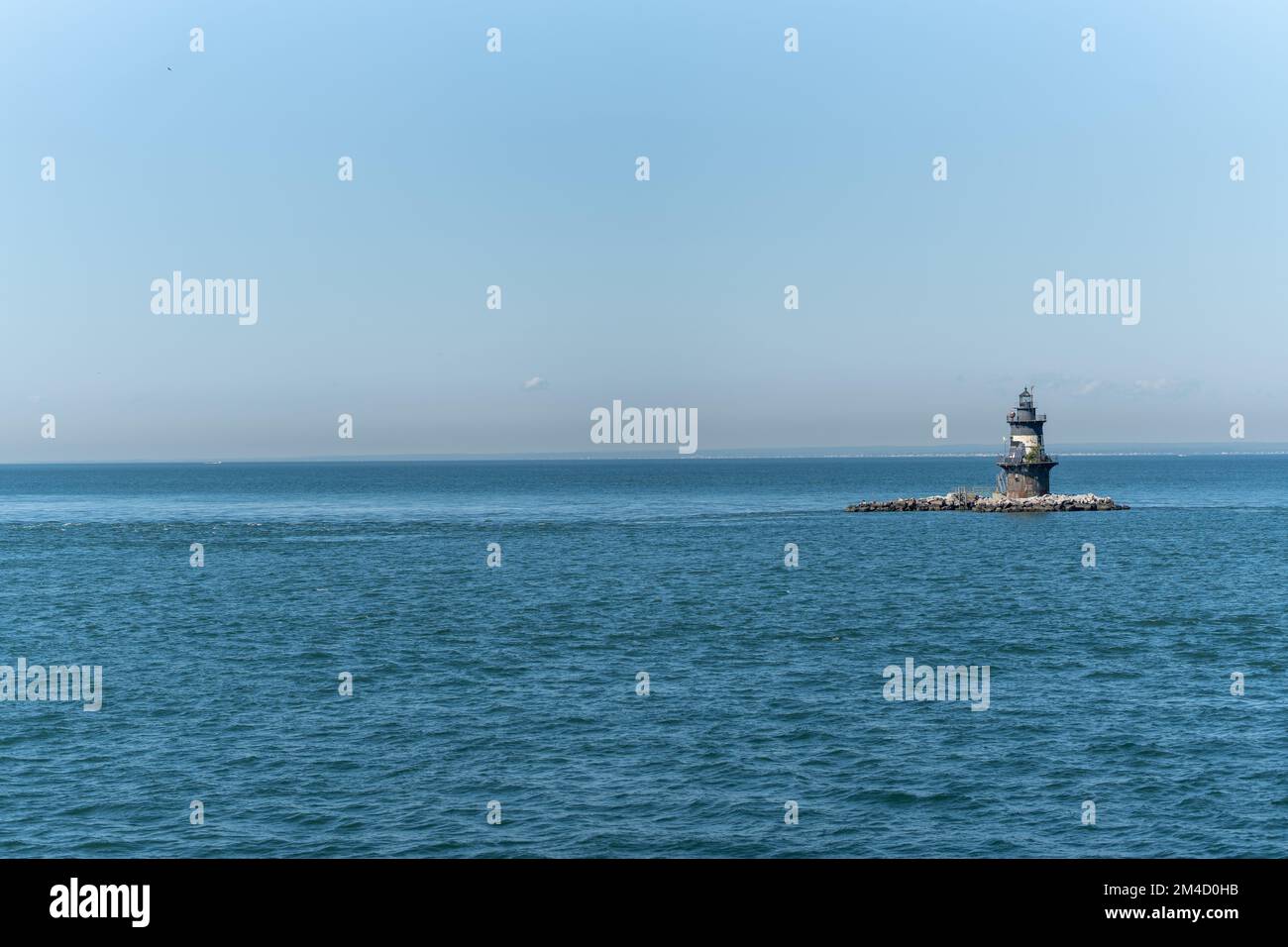 The Orient Point Lighthouse in the blue sea on a sunny day in New York