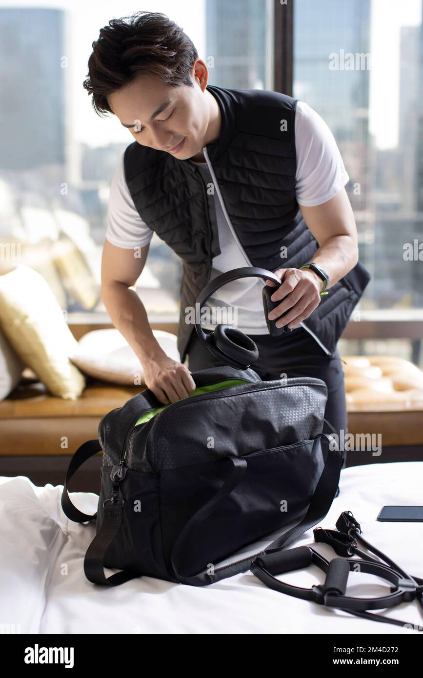 Chinese mid adult man getting ready to go out and workout Stock Photo ...