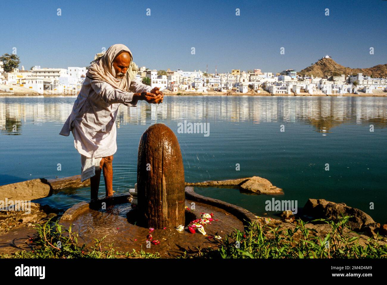 Pilgrim doing morning-pooja, offering prayings to Shiva at the Lake of Brahma. Stock Photo