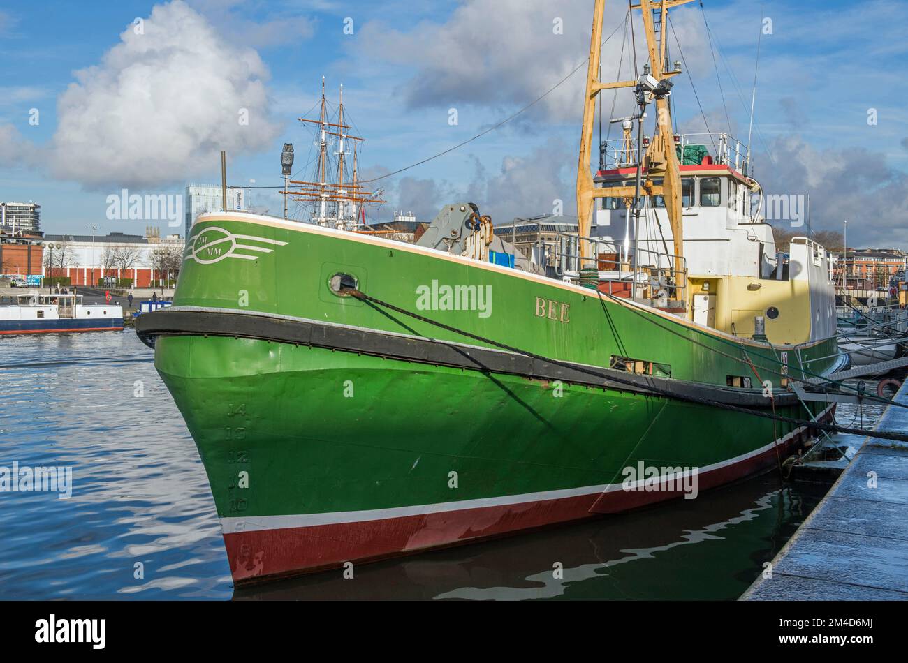 Bee, a green coloured boat, lying moored up in the floating harbour at Bristil in the West Country, on a bright and sunny day. Stock Photo
