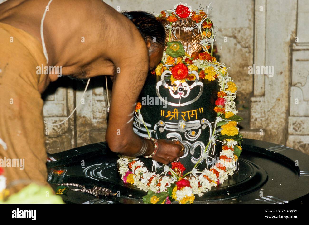 Brahmin preparing a Shiva-Lingam for the Morning Pooja Stock Photo