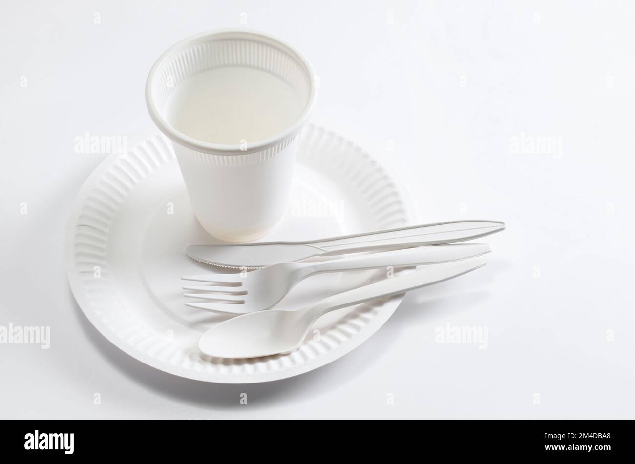 Paper plate, spoon, fork, knife and plastic glass on white background ...