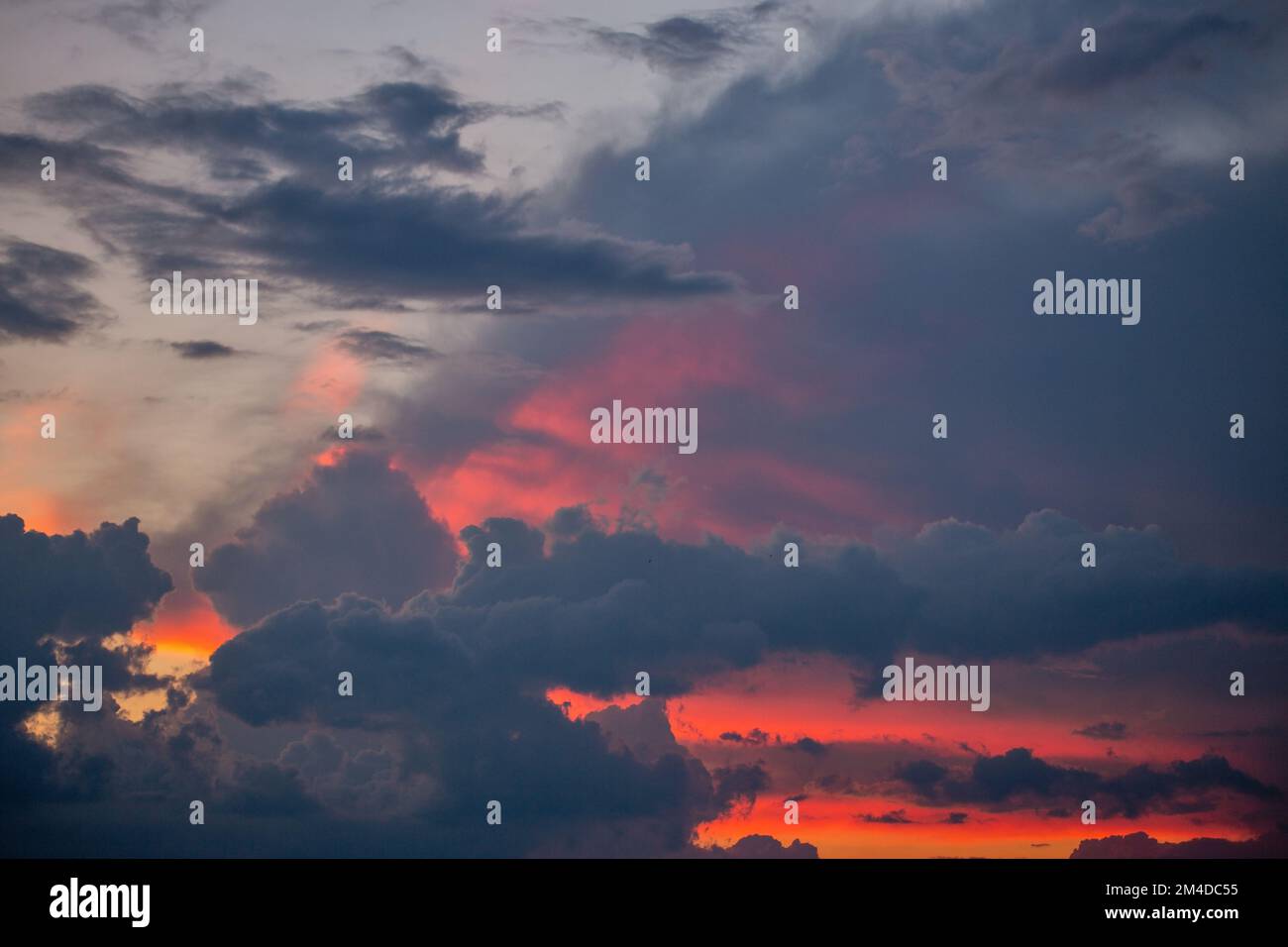 Dramatic sunset cloudscape with blue sky and dark clouds Stock Photo