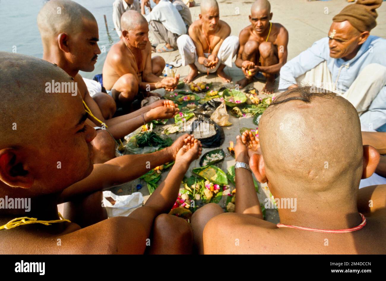 The sons of a died man pray for a good reinkarnation for their father at Har-Ki-Pauri-Ghat in Haridwar Stock Photo