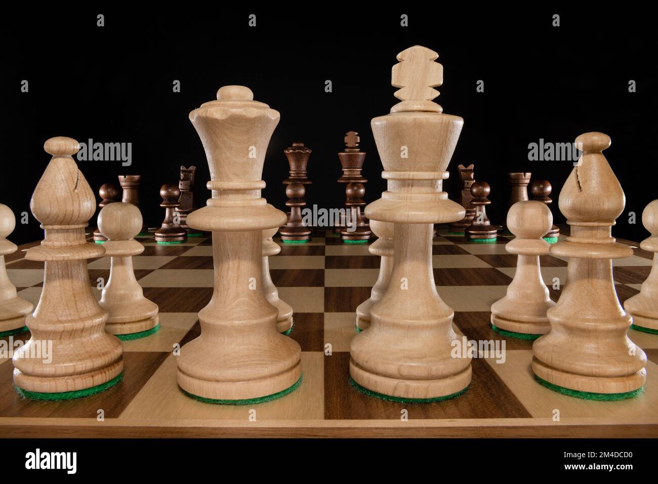 Low angle photo with look at wooden chessboard with view through white pieces to black opposite site Stock Photo
