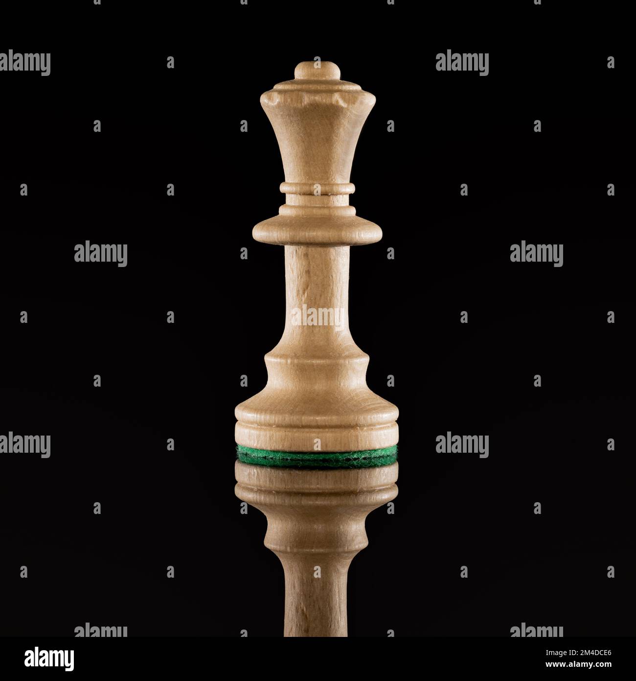 Wooden white chess queen isolated at dark background with transparent reflection on the floor Stock Photo