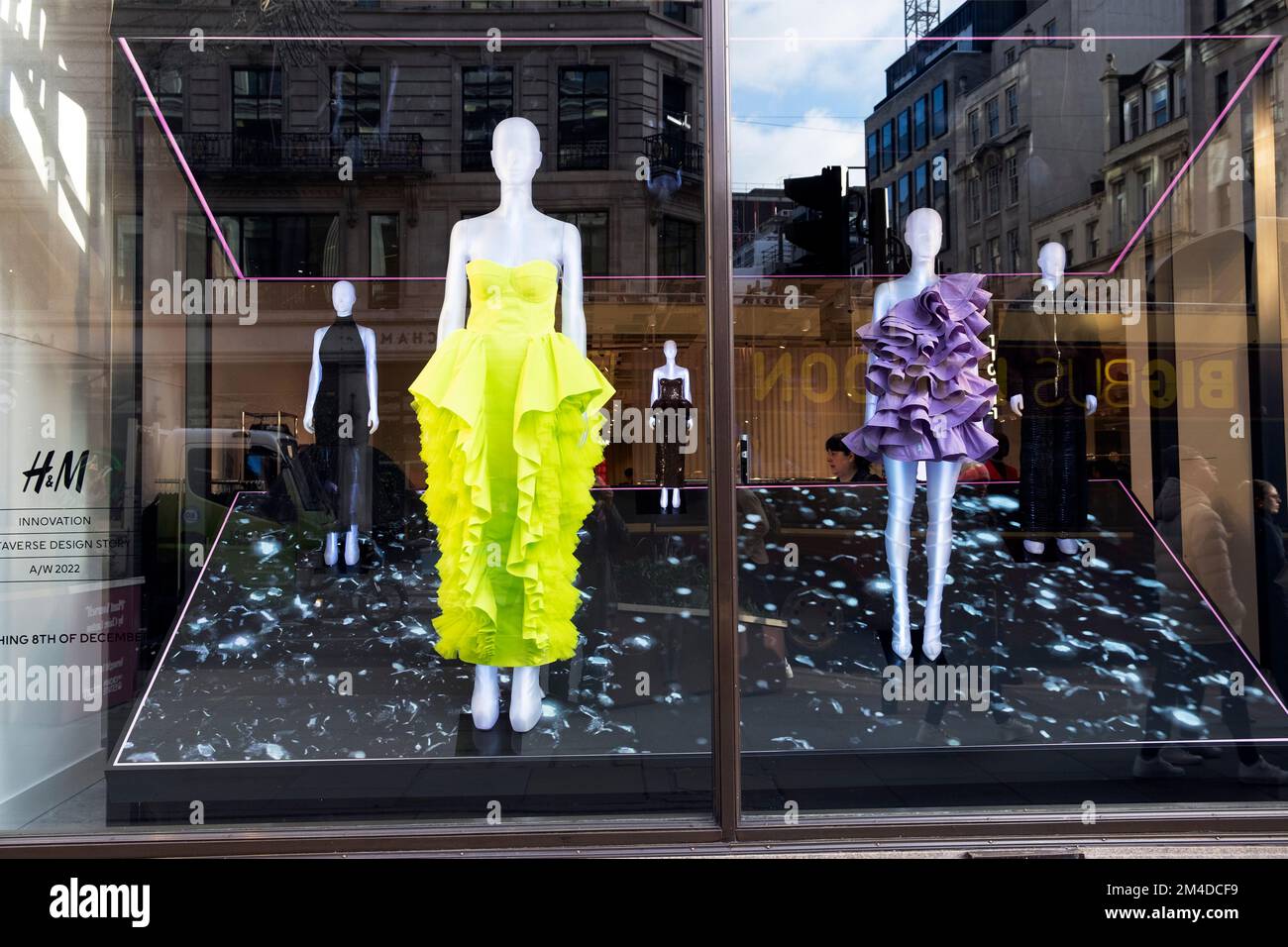 H&M shop window women 's fashion display lime green dress in Regent Street at Christmas time December 2022 West End London England UK  KATHY DEWITT Stock Photo