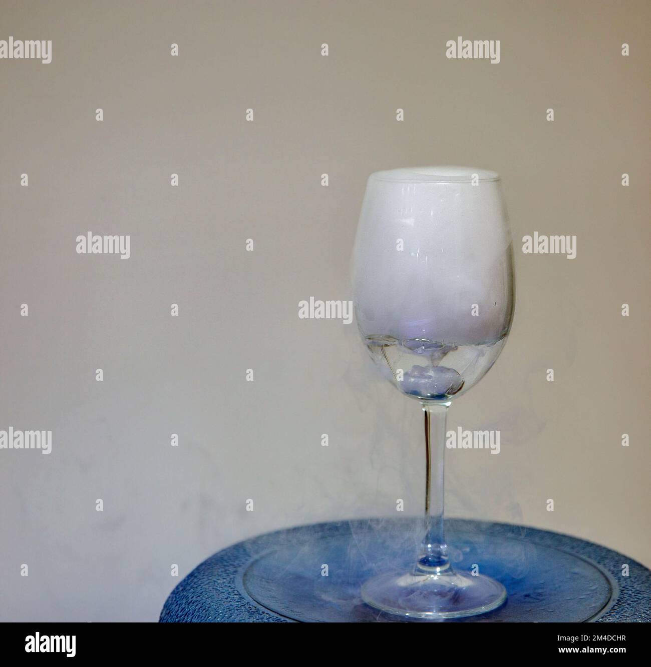 Closeup glass with white fog closeup. Chemical reaction of dry ice with water. Stock Photo