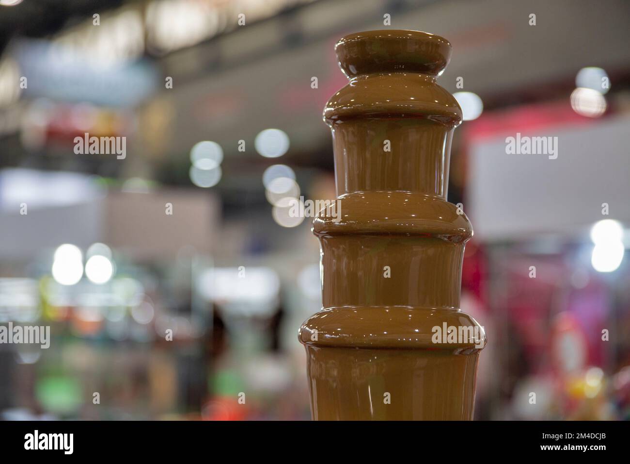 chocolate fountain hot liquid flowing down tower pyramid closeup Stock Photo
