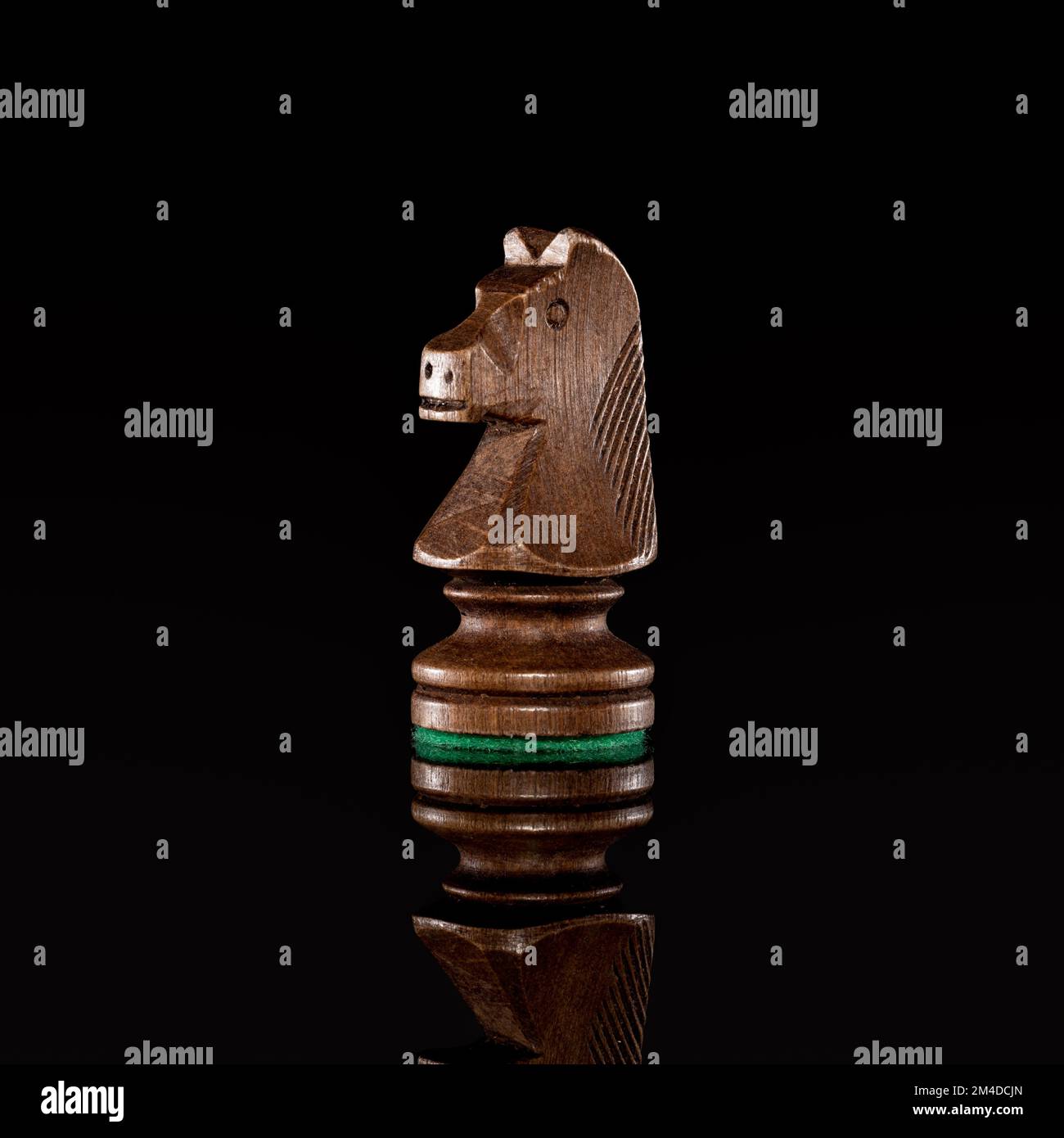 Wooden black chess knight isolated at dark background with transparent