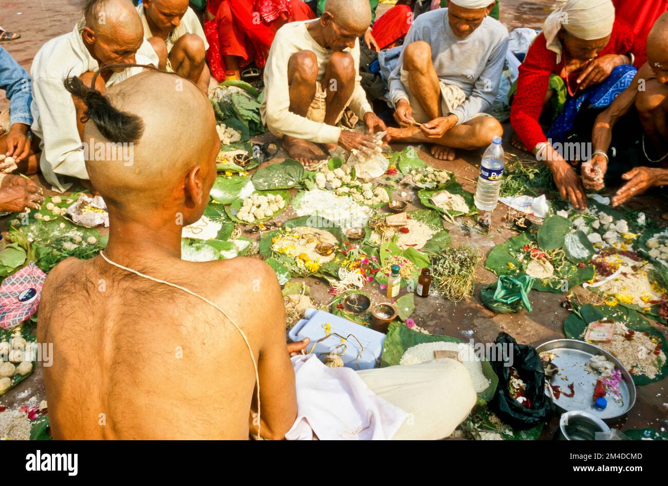 A priest is supporting praying ritual for the good reinkarnation of a died person at Har-Ki-Pauri-Ghat in Haridwar Stock Photo