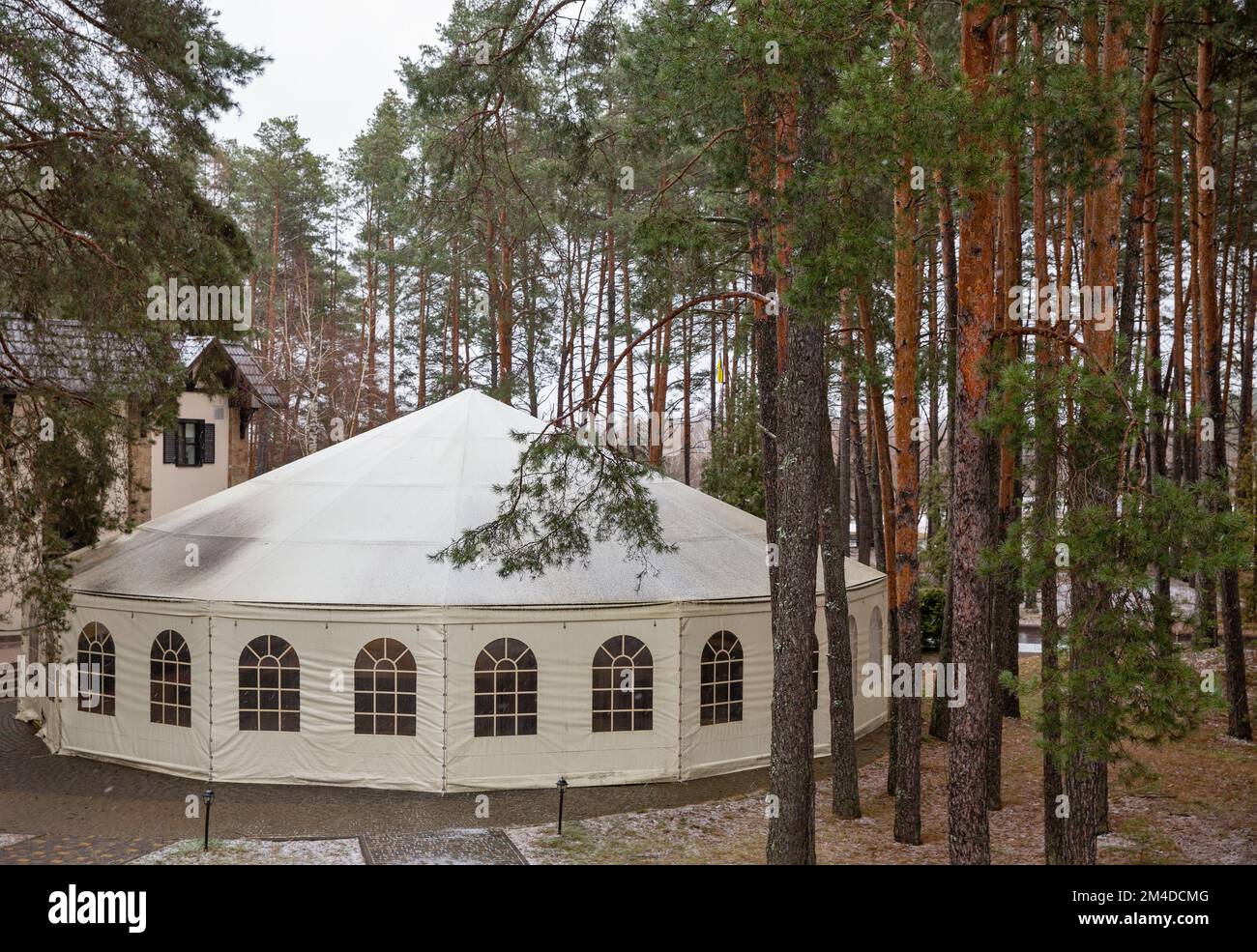 Large closed white tent for celebrations and events in winter forest Stock Photo