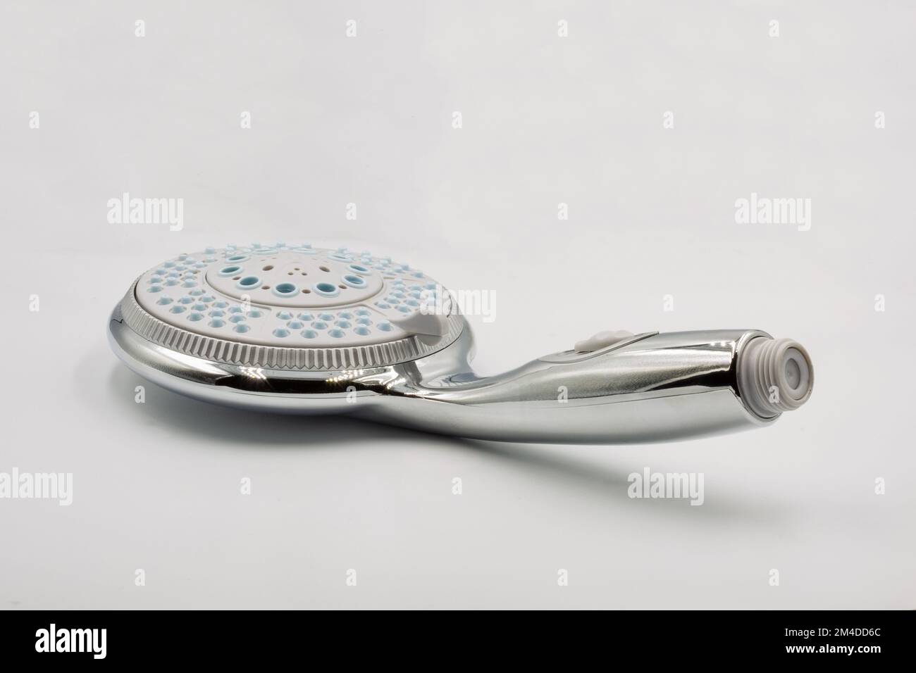New shiny chrome metallic shower head with water spray adjustable closeup on white background Stock Photo