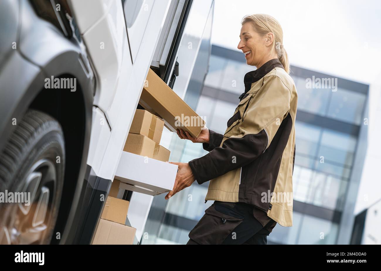 female delivery agent taking out parcels from a van to deliver it to a