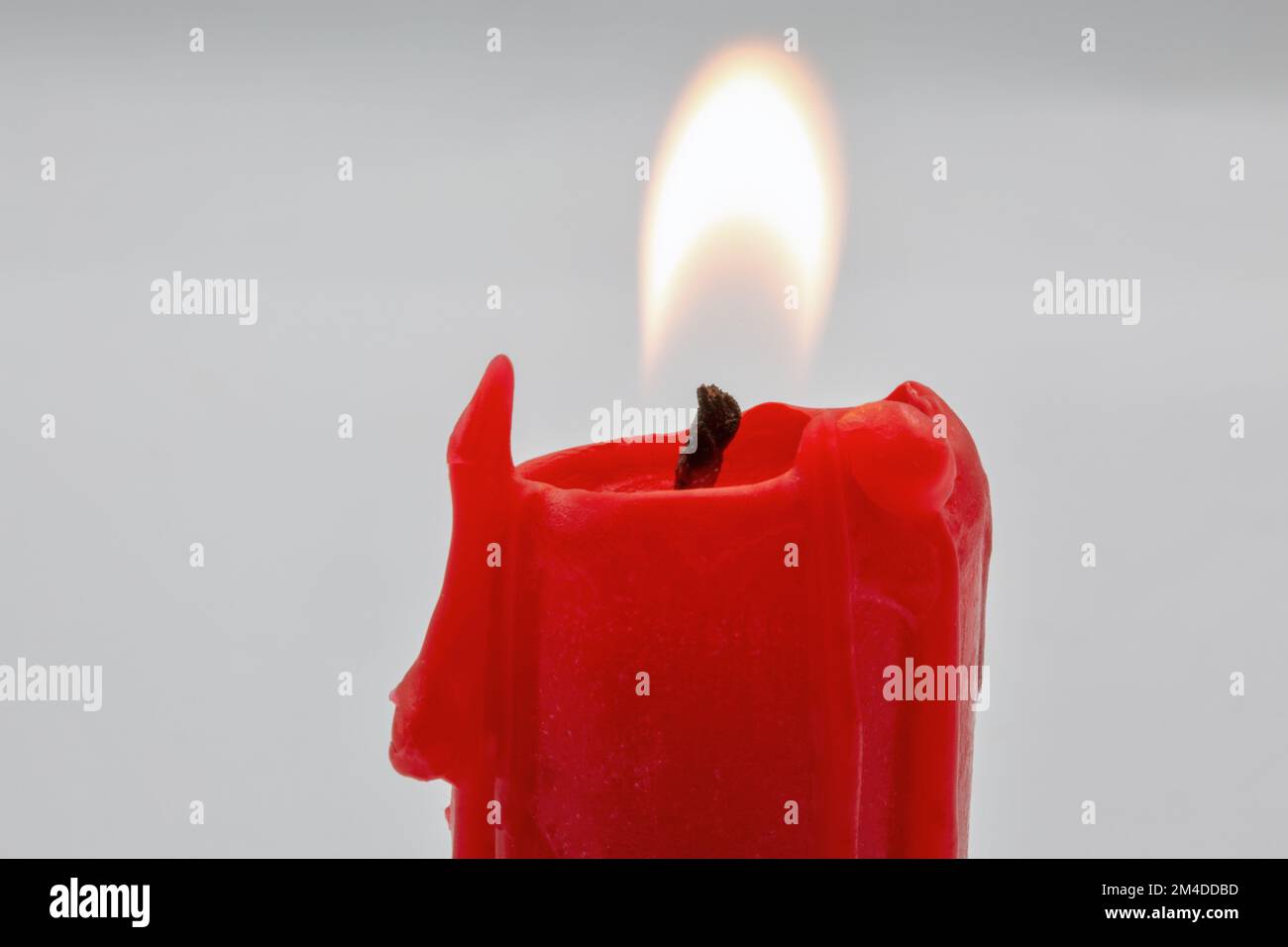 burning small red candle stub closeup on white background Stock Photo