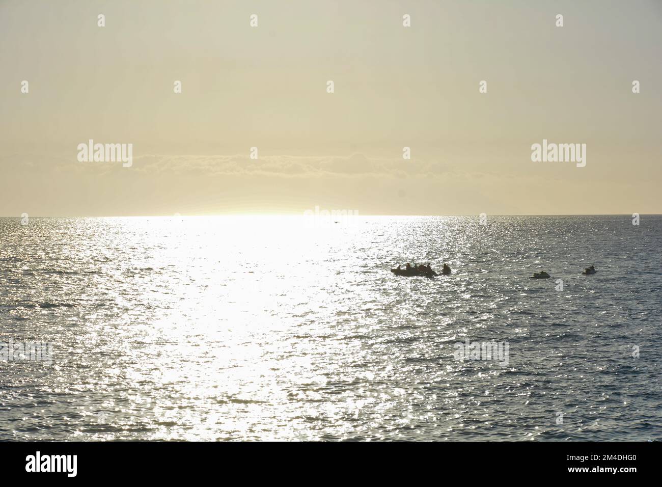 Boats on the sea with reflections by sunset Stock Photo - Alamy
