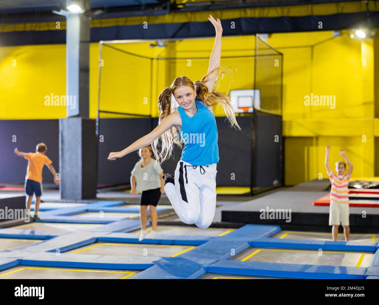 Teenage girl having fun jumping in indoor trampoline arena Stock Photo ...
