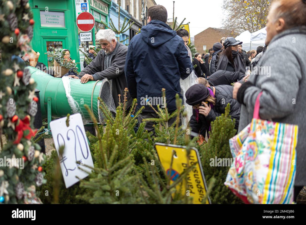 London, Uk - 17 December 2022, Columbia Road Flower Market is a street market. A man sells a fir tree and wraps it in a special package Stock Photo