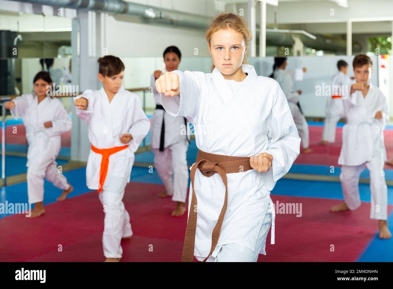 Girl in kimono posing during karate group training Stock Photo - Alamy