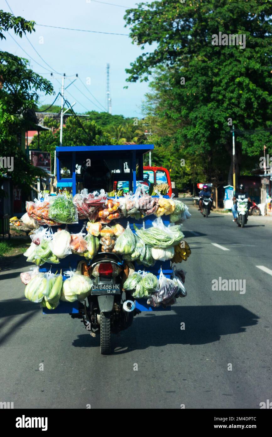 Motor scooter laden with fresh vegetables and other items. Stock Photo