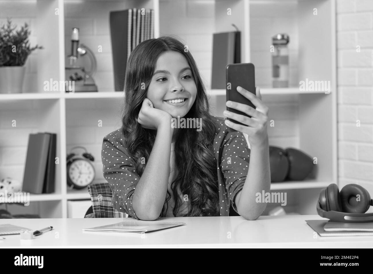 blogging on phone. vlogger with cellphone having curly hair. glad teen girl blogger Stock Photo
