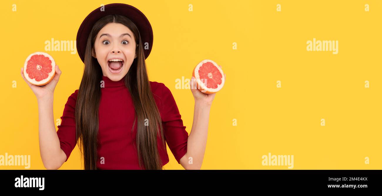 surprised child eating healthy food. childhood health. citrus fruit. organic fresh grapefruit. Child girl portrait with grapefruit orange, horizontal Stock Photo