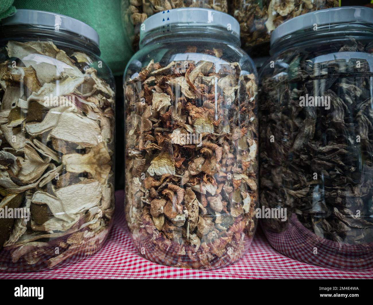 Large glass jars full of Dried Mixed Wild Mushrooms. Selective focus Stock Photo