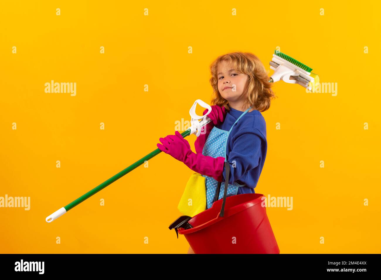 Studio portrait of child helping with housework, cleaning the house