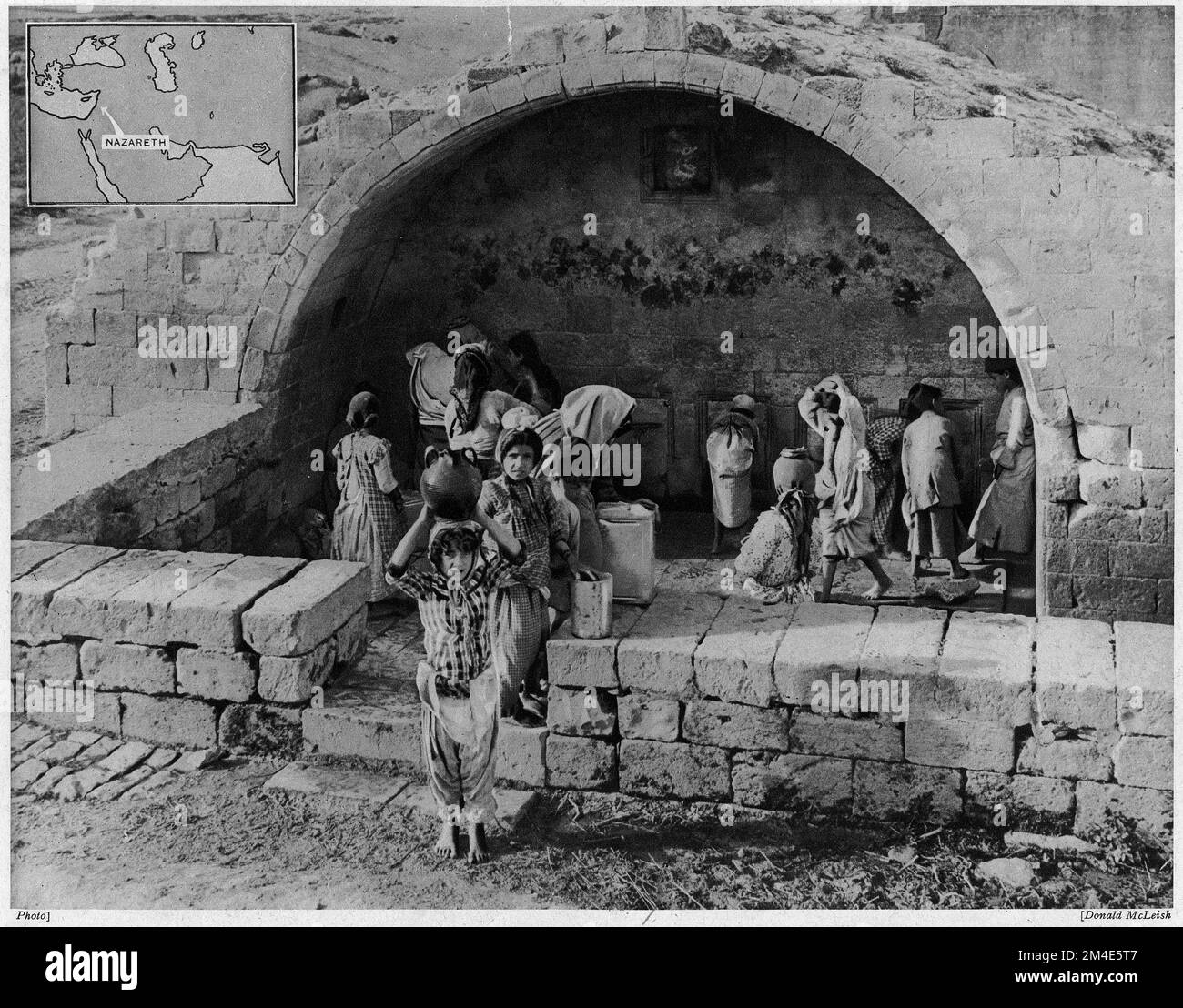Halftone of children drawing water from the well in Nazareth, from an educational publication in 1927. Stock Photo