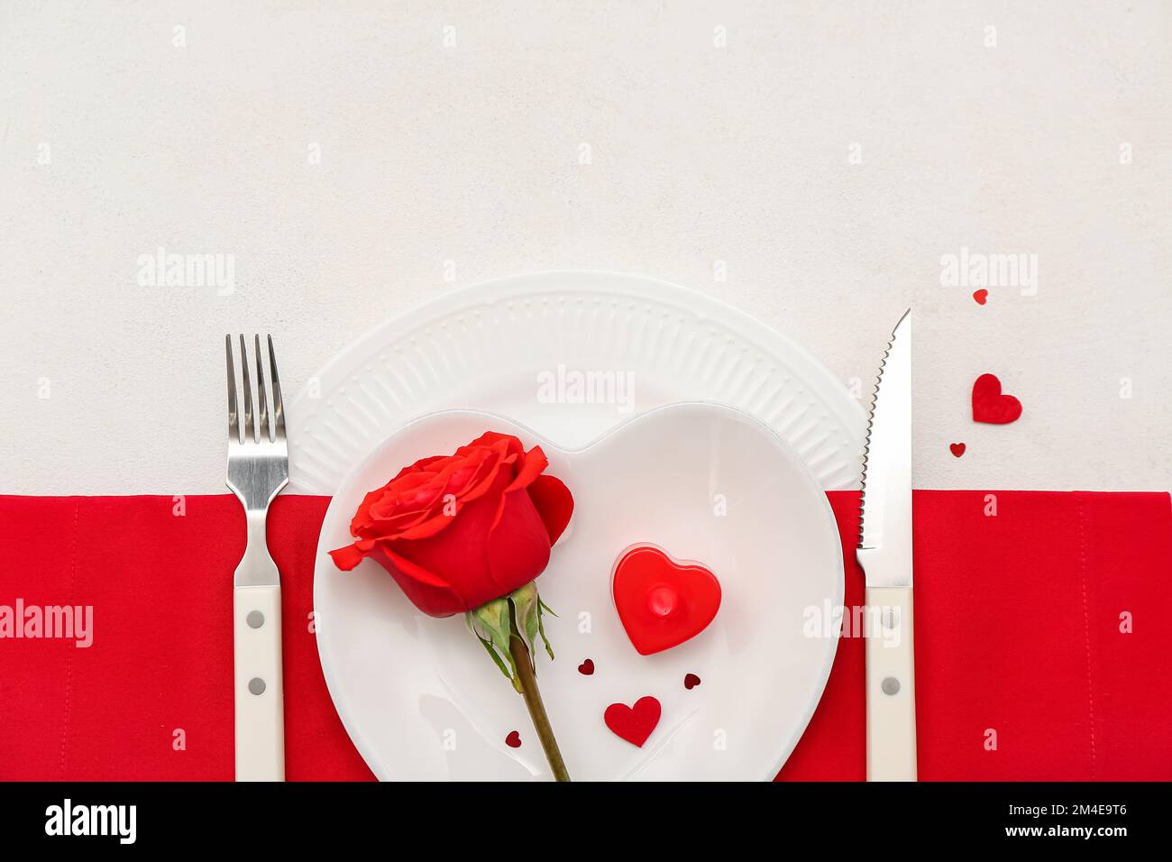 Table setting for Valentine's Day with rose and hearts on white ...