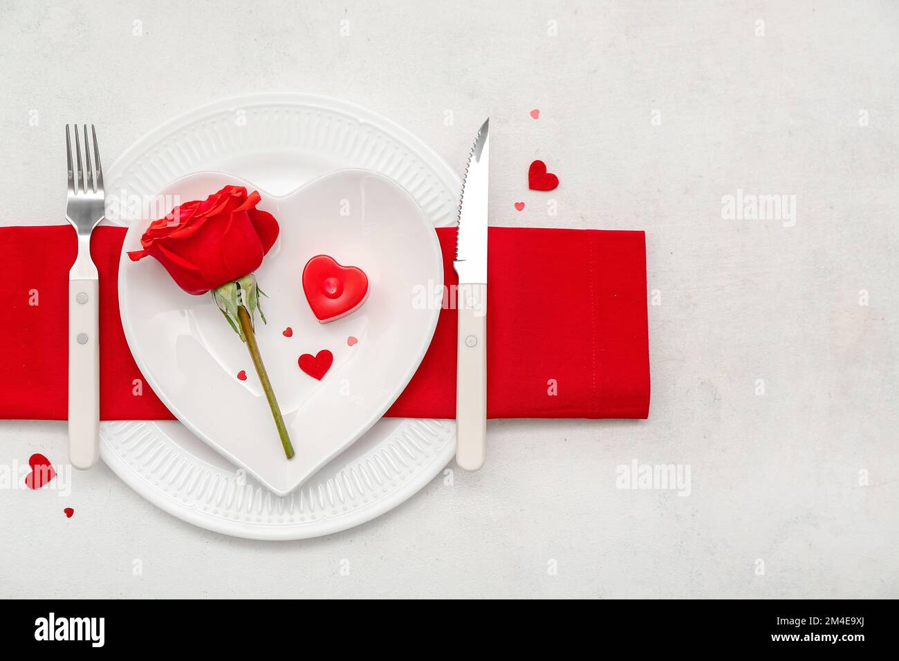 Table setting for Valentine's Day with rose and hearts on white ...