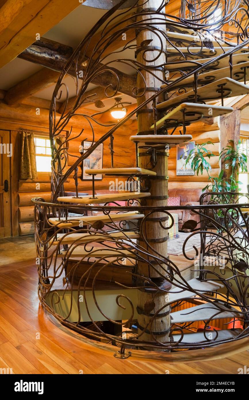 Spiral shaped wood and wrought iron staircase in living room inside ...