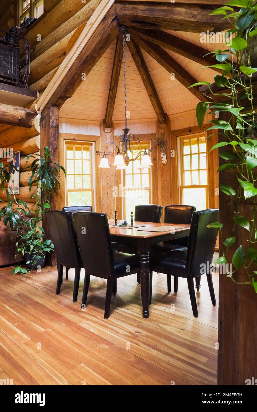 Black wooden dining table and leather high back chairs in dining room
