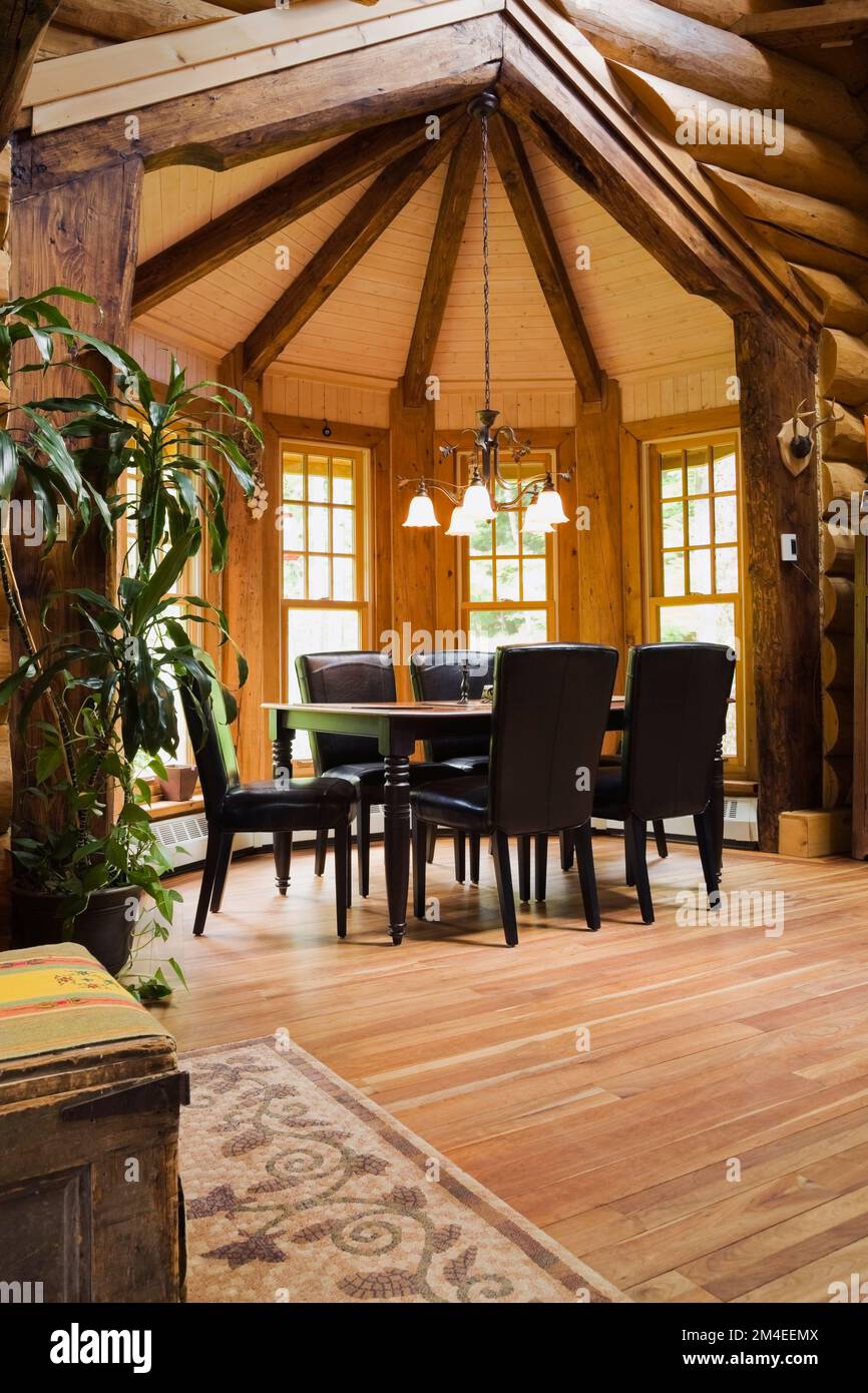 Black wooden dining table and leather high back chairs in dining room