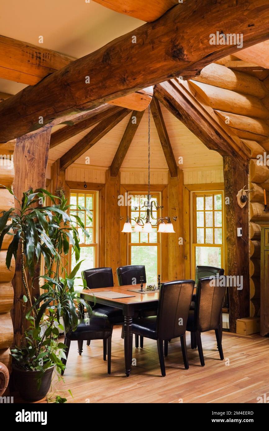 Black wooden dining table and leather high back chairs in dining room