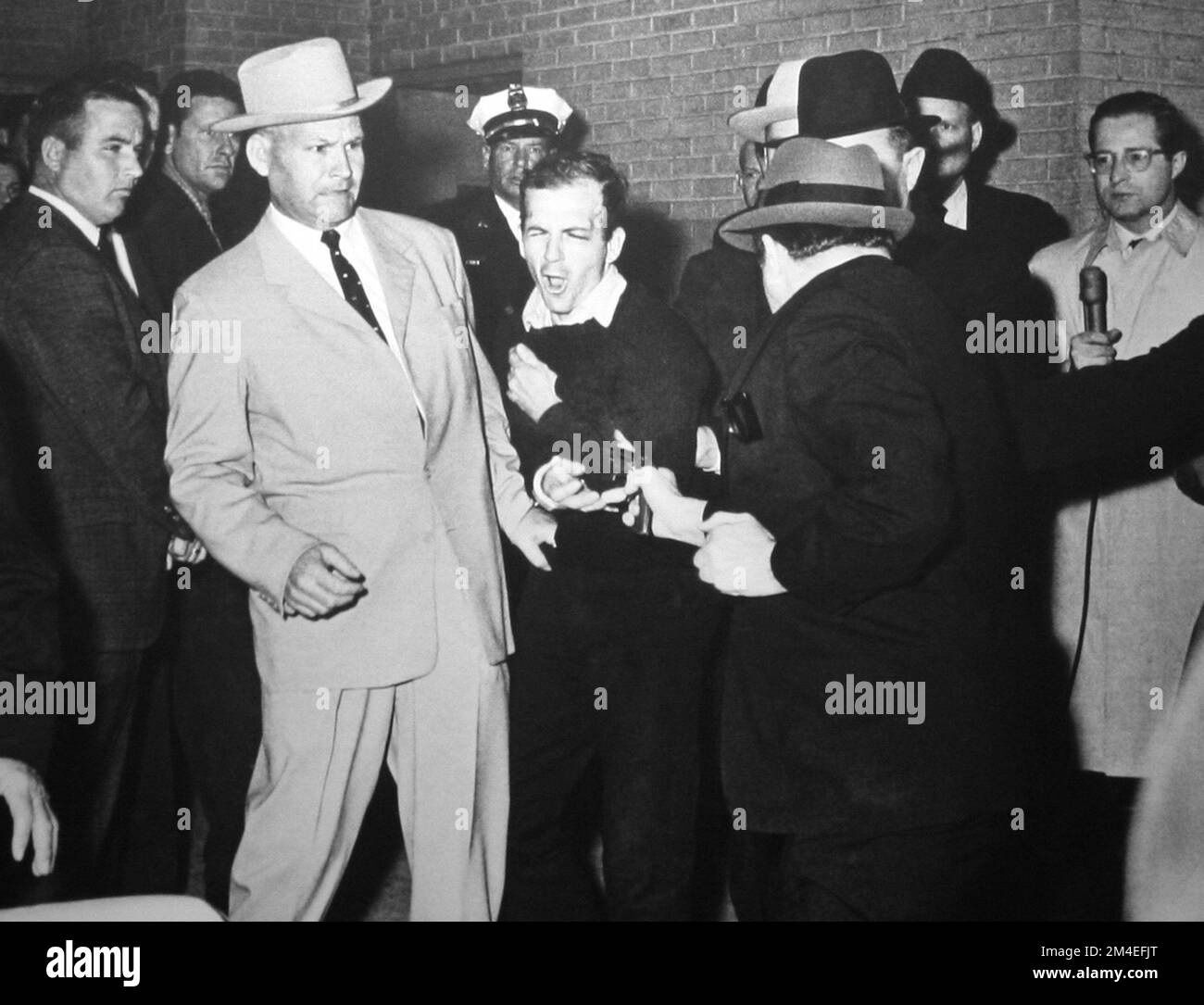 After the assassination of JFK, Jack Ruby shooting Lee Harvey Oswald, who was being escorted by police detective Jim Leavelle (tan suit) for the transfer from the city jail to the county jail. Stock Photo